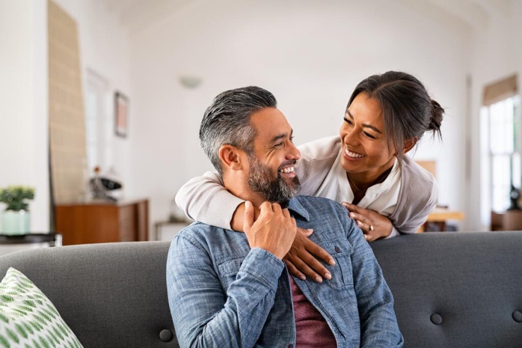 couple smiling while expressing emotions to one another in a healthy way