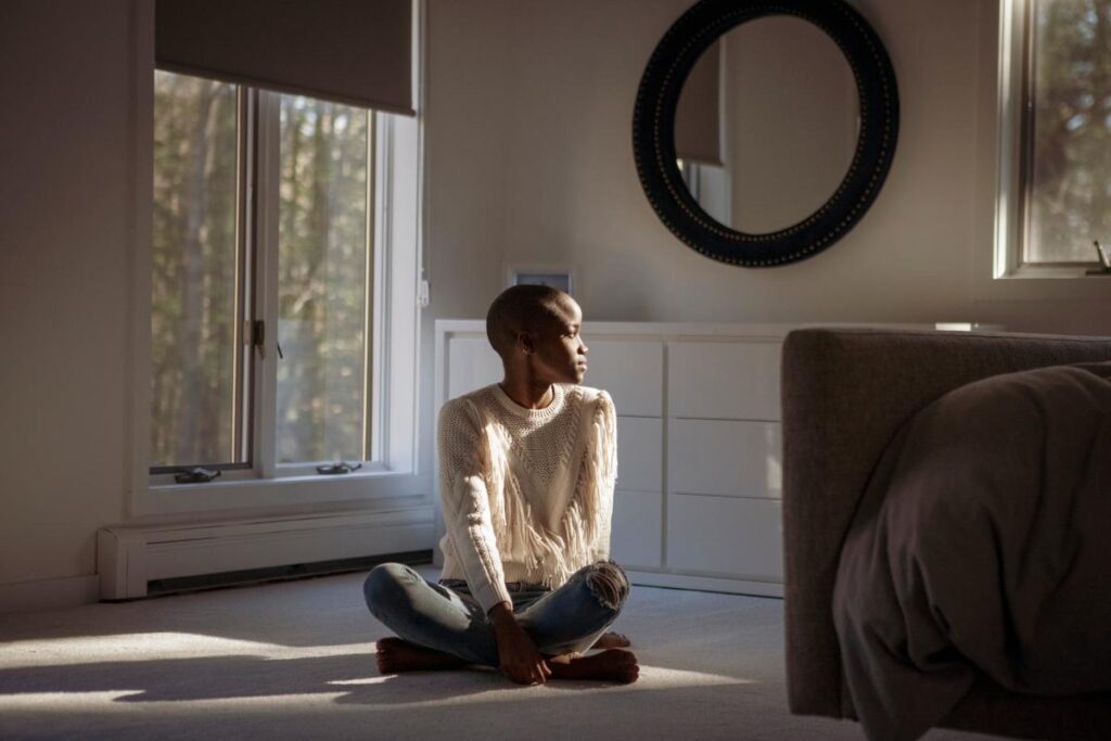 person sitting cross legged in naturally lit room trying to find a sense of calm while experiencing separation anxiety