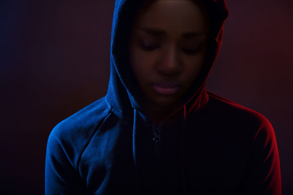 person in hoodie in the dark going through stages of withdrawal