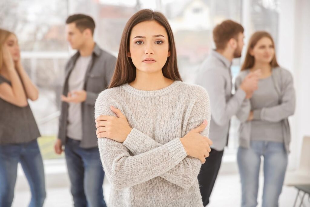 person in group of people with arms crossed experiencing social anxiety