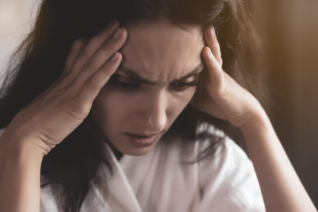 person rubbing temples while struggling with complex ptsd