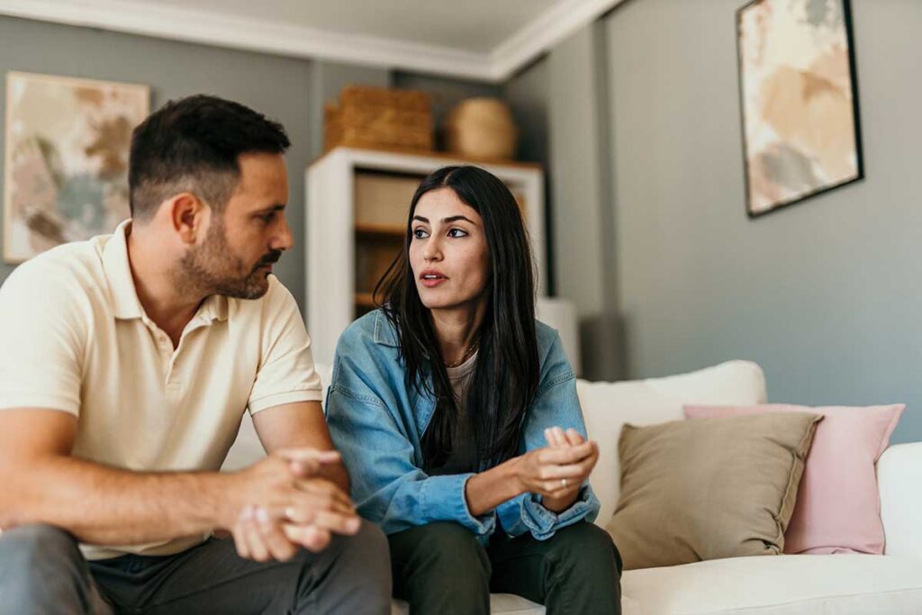 couple sitting on couch talking while in therapy for sex addiction