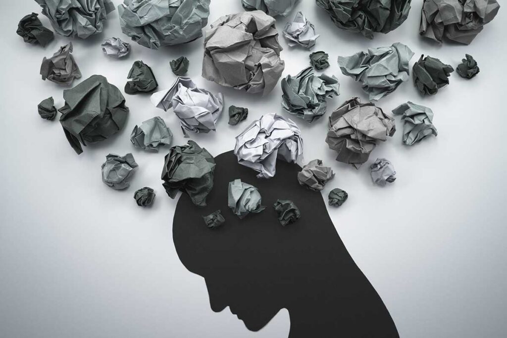 artwork with black silhouette of head and crumpled paper flying out of it to illustrate how does heroin affect the brain