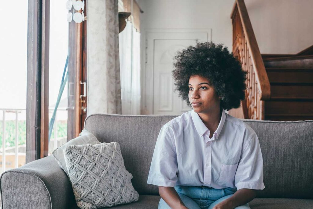 person on couch looking out of window while struggling with opioid withdrawal symptoms